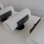 Set of four wall lights in white plexiglass and perforated black metal.