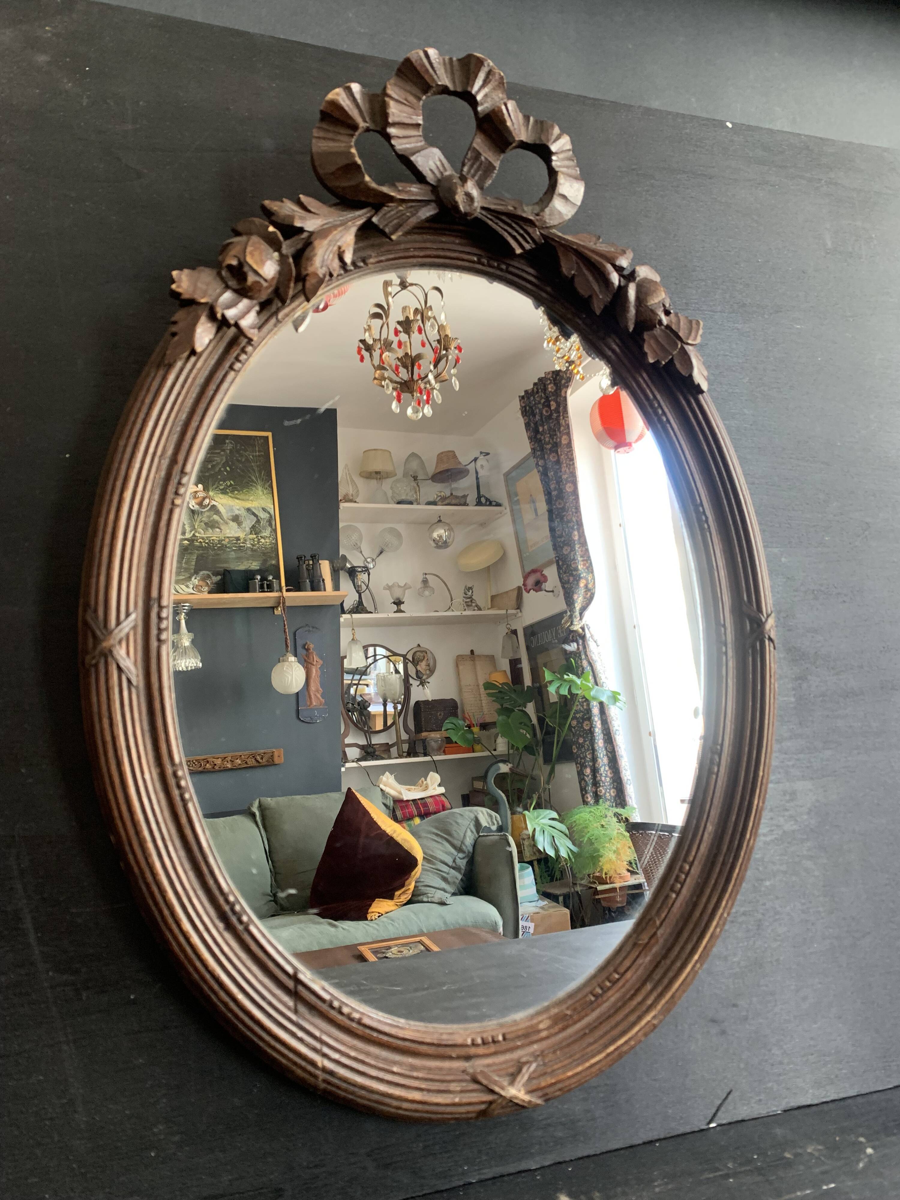 Antique oval mirror in carved wood and Louis XVI style knot