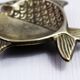 Vintage fish-shaped brass pocket emptier