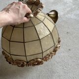 Vintage pendant light with a pearlescent shade and floral decoration.