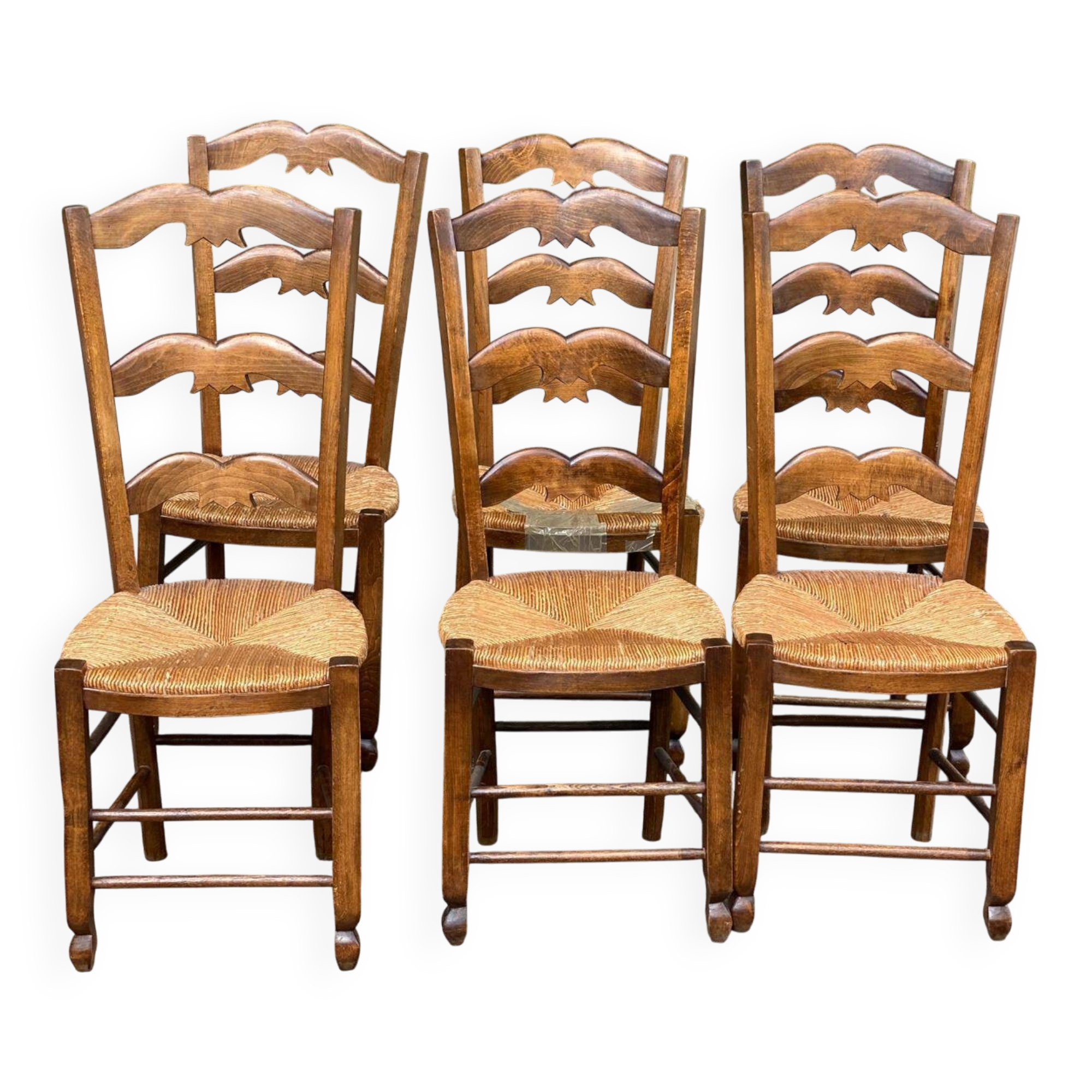6 solid wood chairs with straw seats and butterfly carved backs.