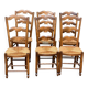 6 solid wood chairs with straw seats and butterfly carved backs.