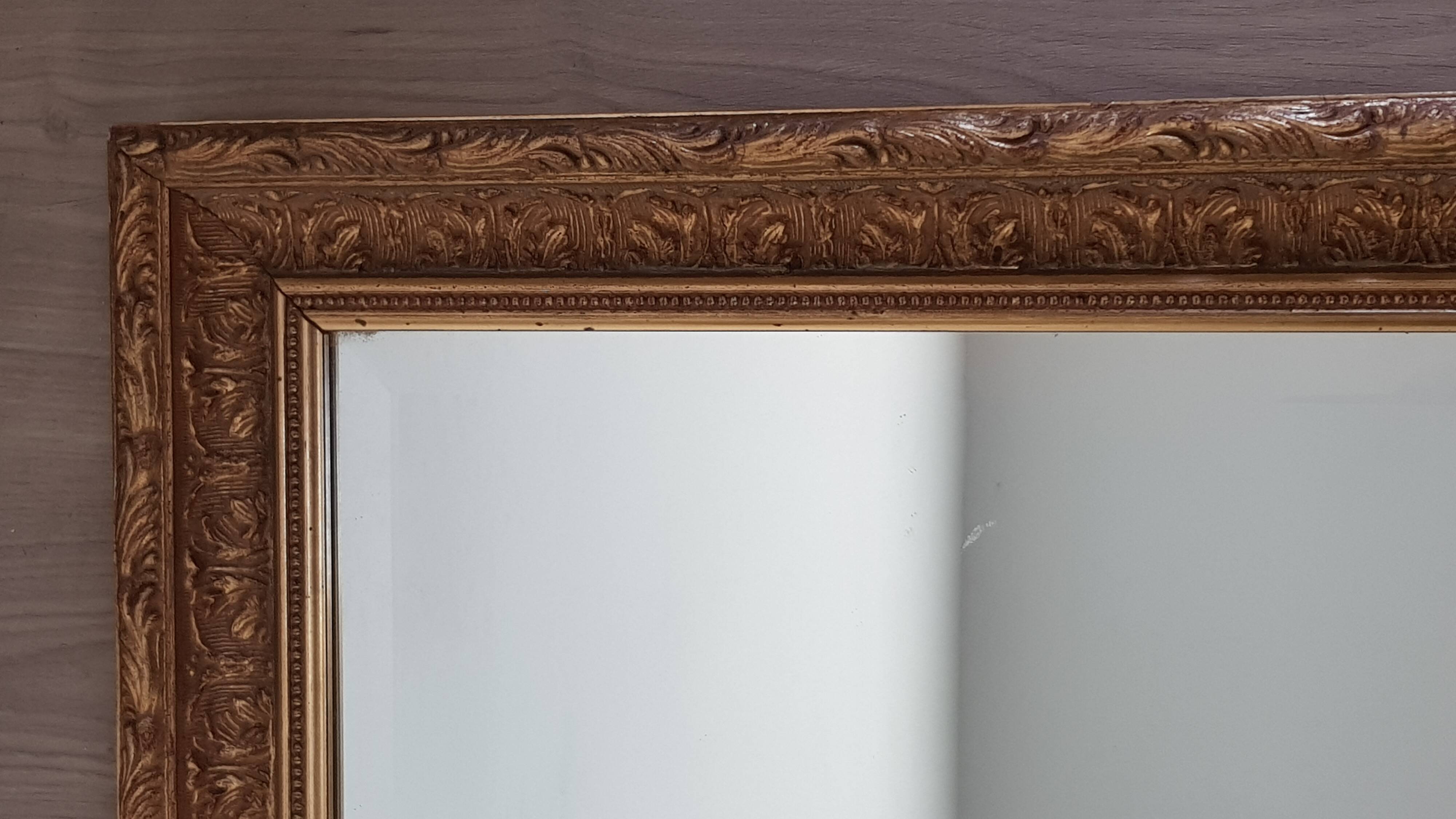 Mirror in gilded stucco wood and beveled glass