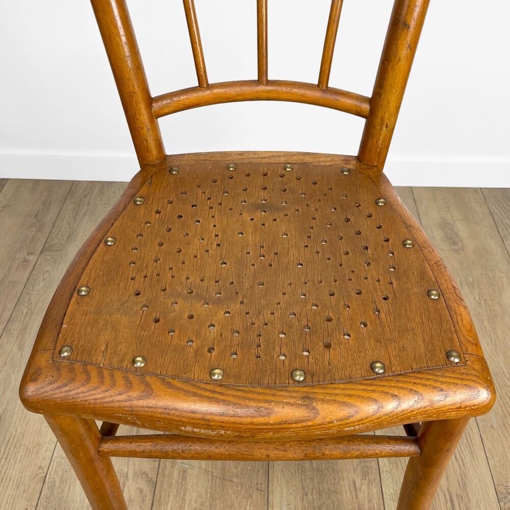 Pair of curved wood bistro chairs and studded and perforated seat
