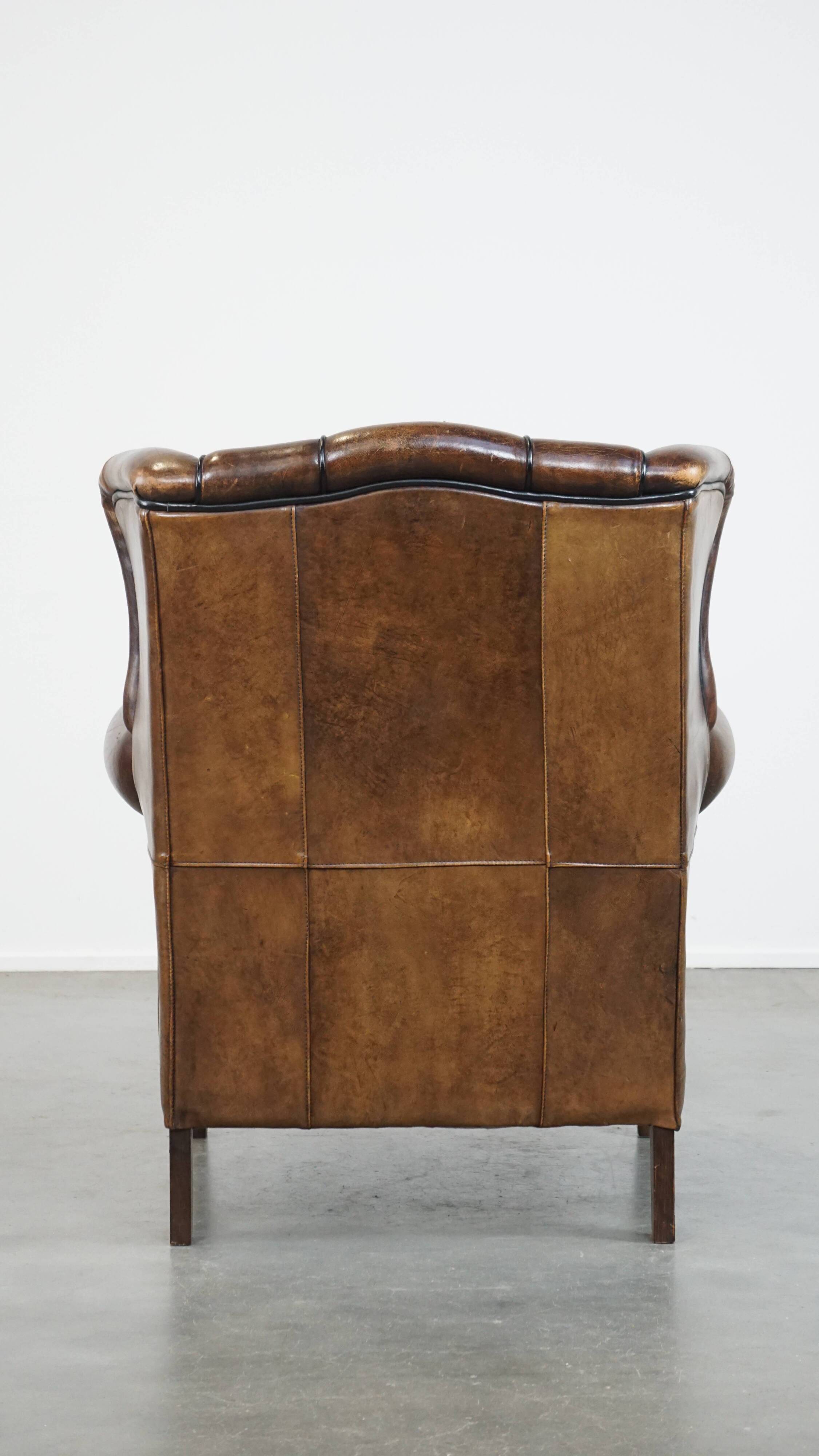 Vintage sheepskin wingback chair finished with black piping