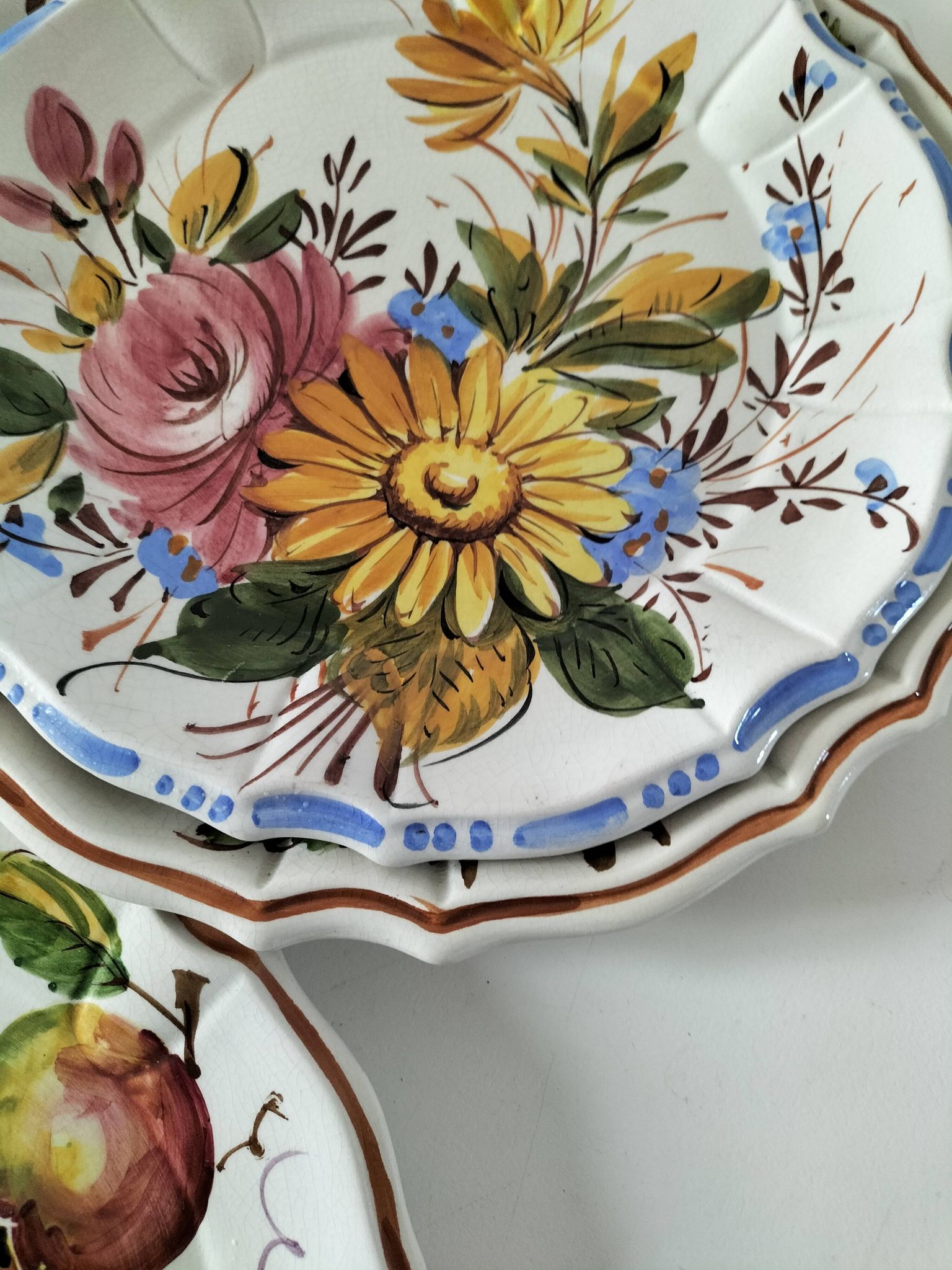 Set of three earthenware plates from Bassano, hand-painted with fruit and flower designs.