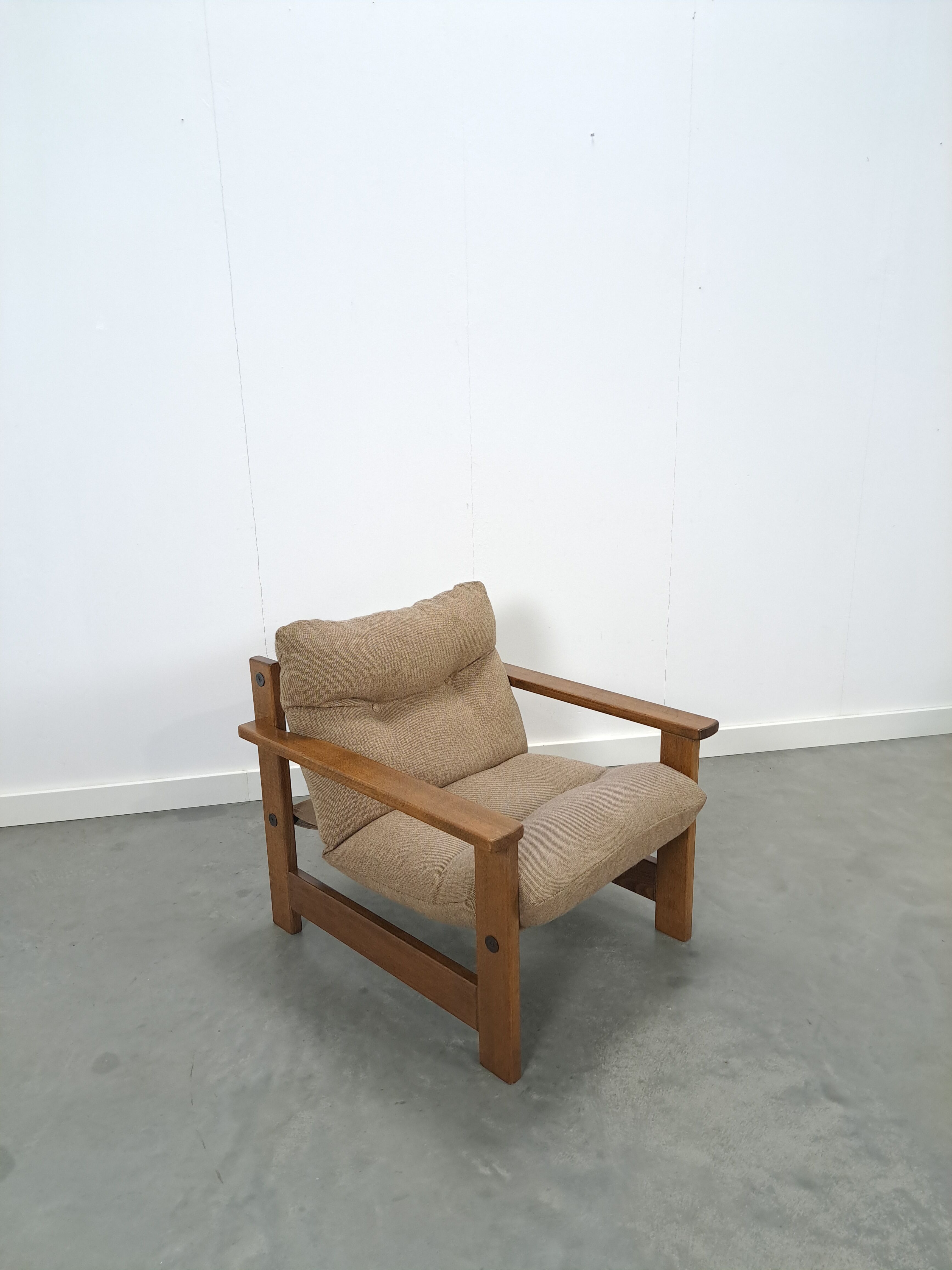 Brown-grey armchair with an oak frame.