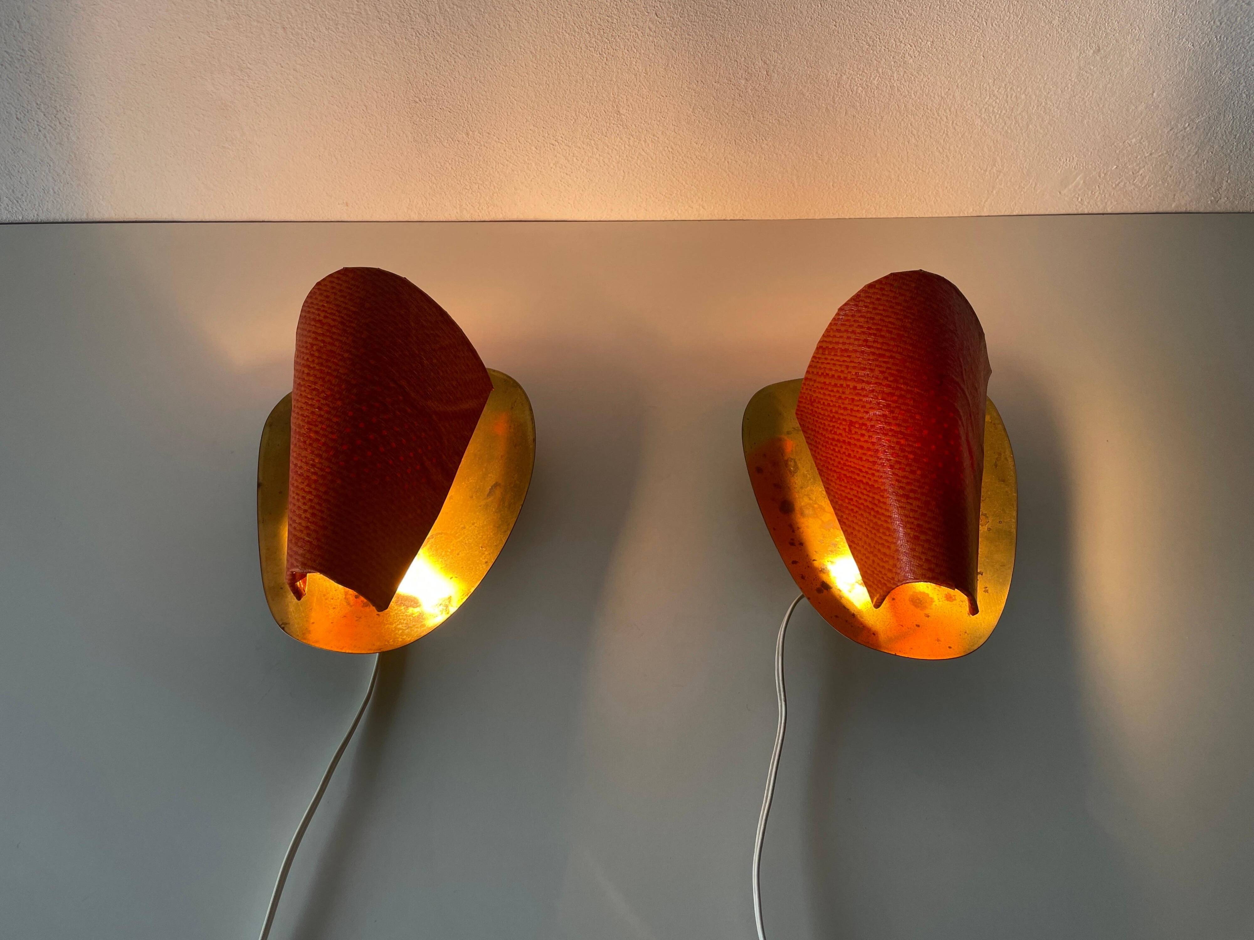 Pair of orange plexiglass and curved brass wall lights, 1950s, Germany