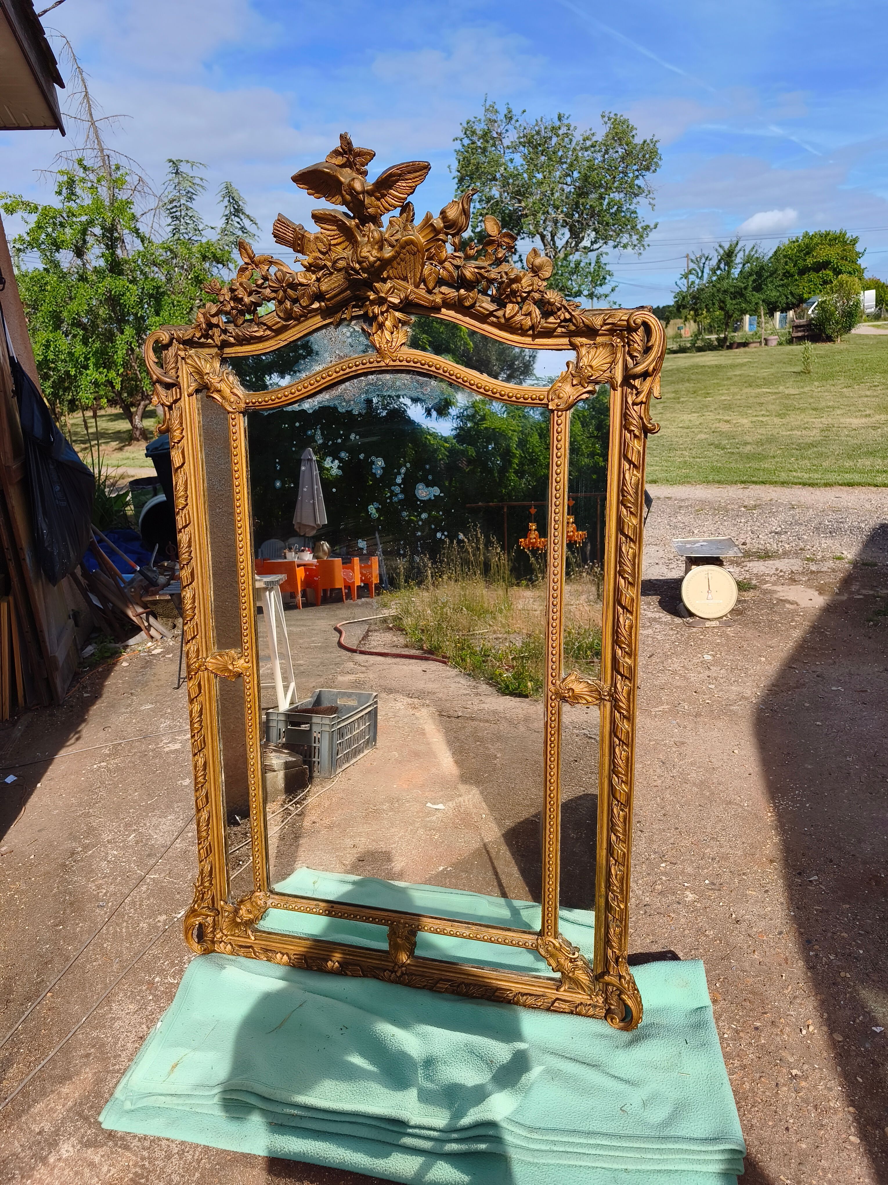 Large closed mirror, 19th century, wood and gilded stucco.