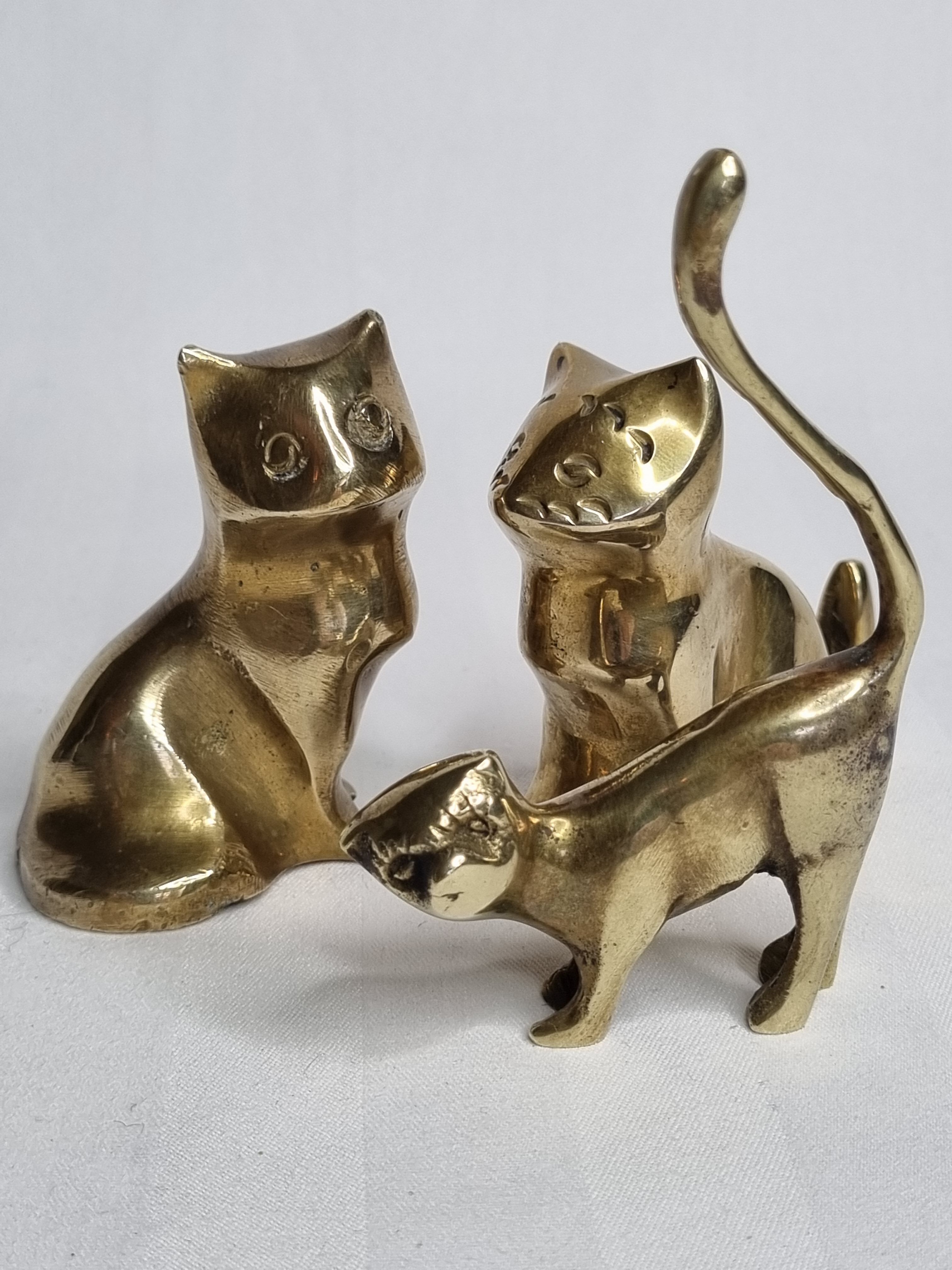 Set of three brass cats