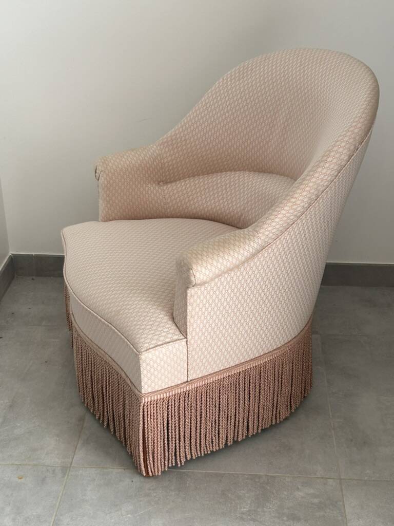 Pink armchair with patterns and fringes.