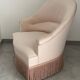Pink armchair with patterns and fringes.