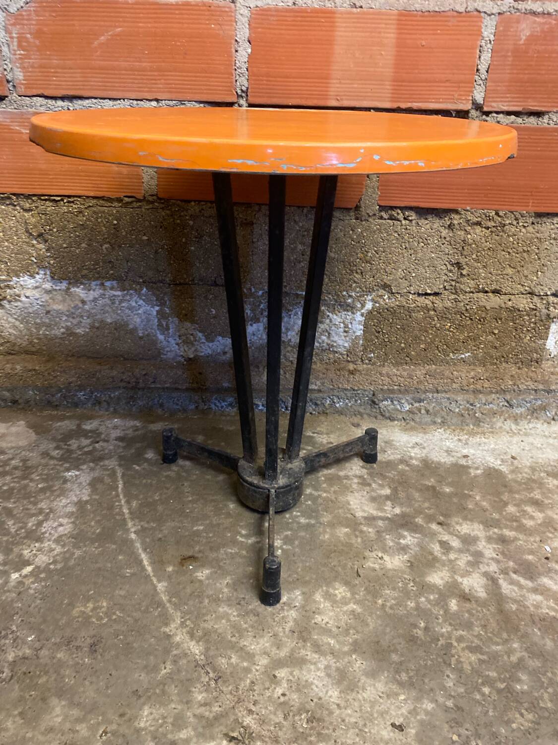 Vintage bistro table with black cast iron base and orange bakelite top, 1950s