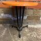 Vintage bistro table with black cast iron base and orange bakelite top, 1950s