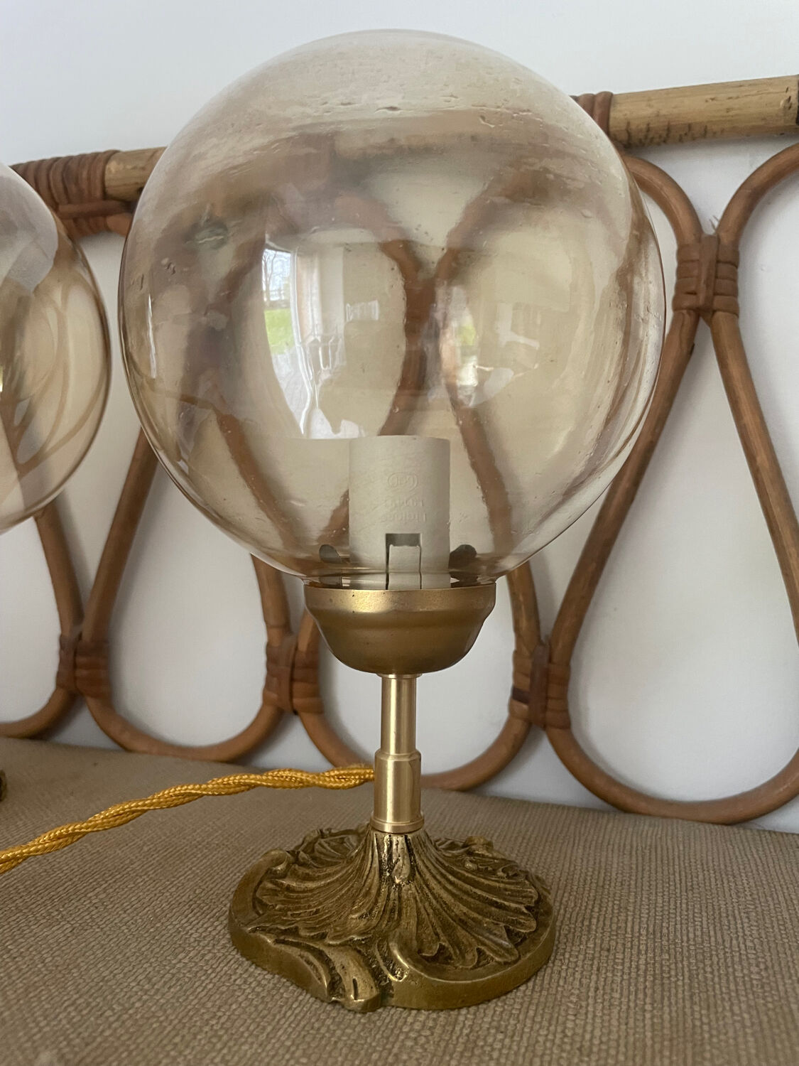 2 bedside lamps with round amber glass globes and gold metal.