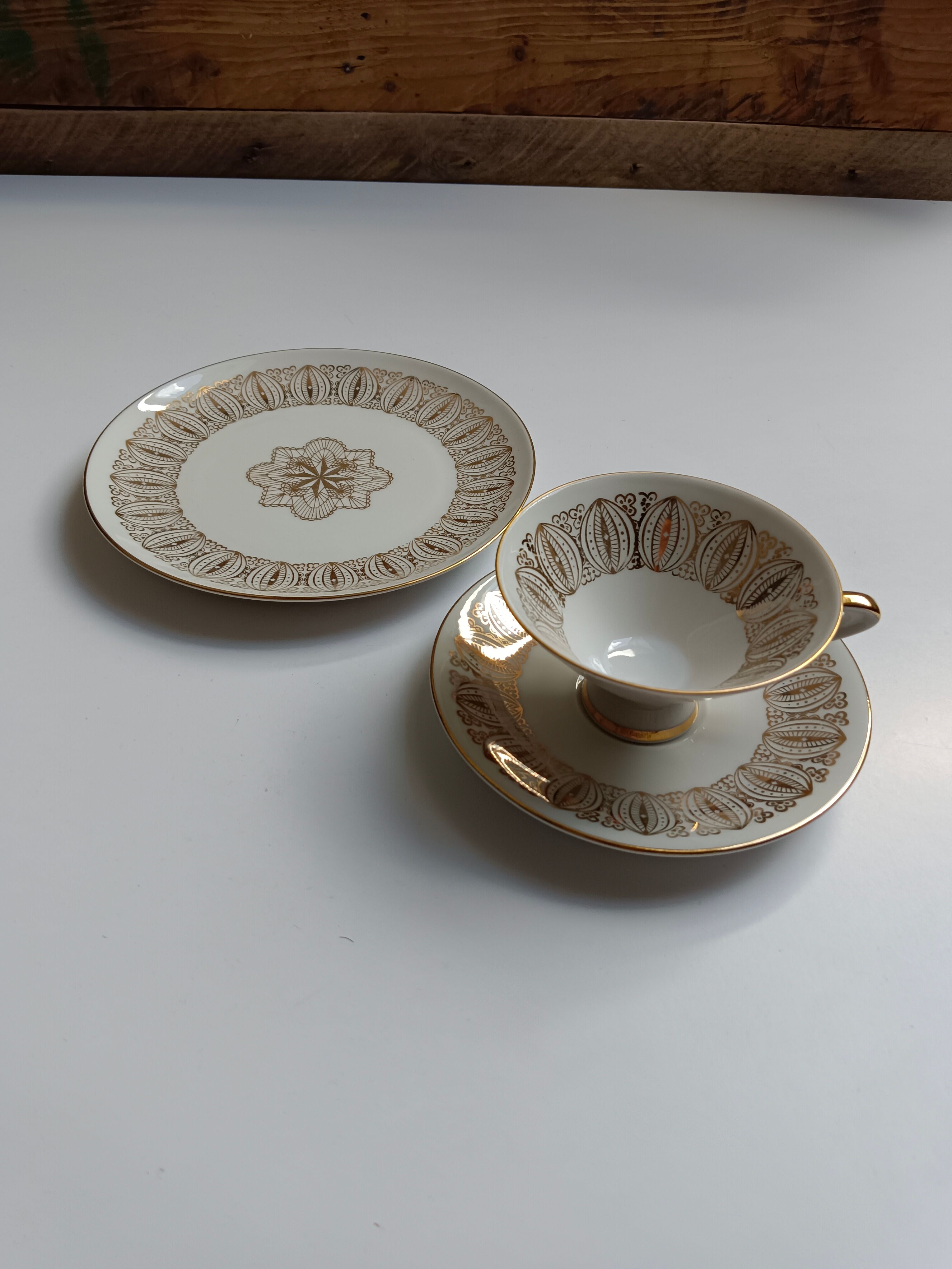 Solitaire tea cup, saucer, and dessert plate in white and gold.