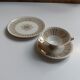 Solitaire tea cup, saucer, and dessert plate in white and gold.