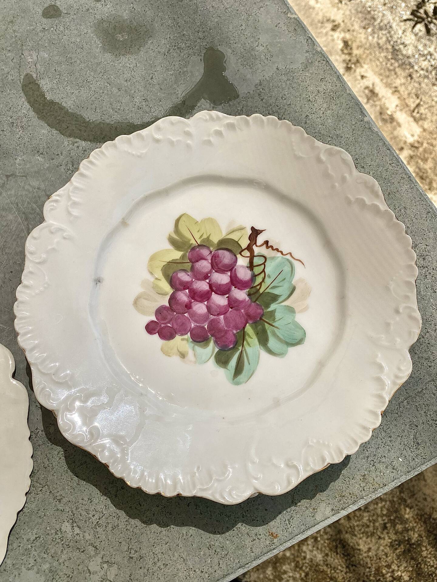 Antique plates from the late 19th century with scalloped edges and fruit decoration.