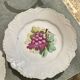 Antique plates from the late 19th century with scalloped edges and fruit decoration.