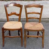 2 solid oak carved and rush-seated chairs in the Louis Philippe style, 19th century.