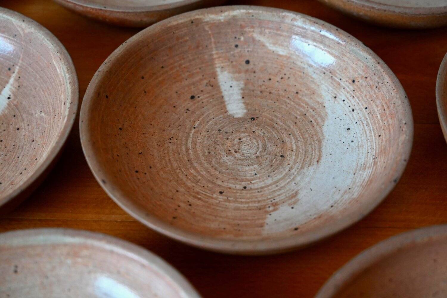 Set of 10 turned stoneware plates, pyritised and glazed, wabi-sabi brutalist.