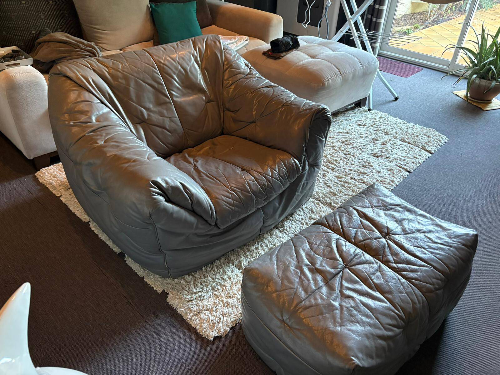Sloop armchair and pouf from Ligne Roset in grey leather.