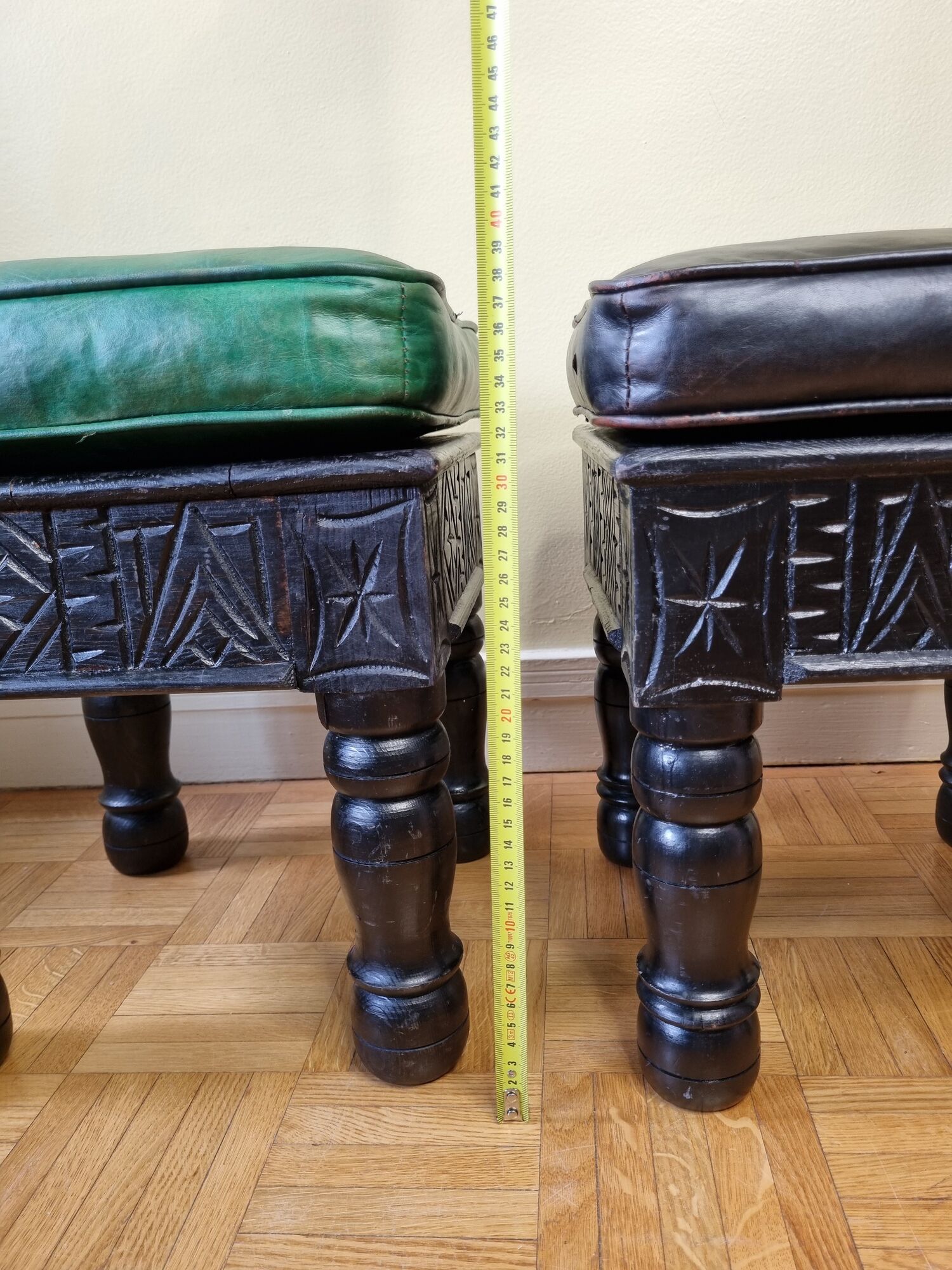 Pair of Moroccan poufs in stamped leather with a carved wooden base, Rabat