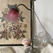 Antique jeweller's lamp, silver-plated base, frosted pink glass shade.
