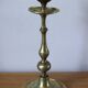 Brass candle holder with flowers and round shape.