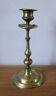 Brass candle holder with flowers and round shape.