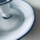 Old candle holder in white enameled metal