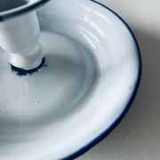 Old candle holder in white enameled metal