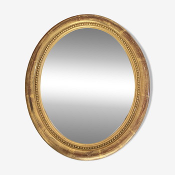 Miroir ovale en bois doré.