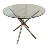 Round glass dining table with a chrome central base.