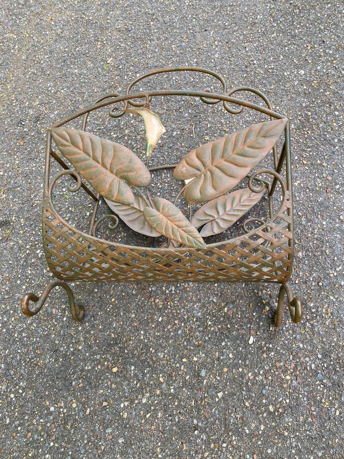 Vintage wrought iron magazine rack with flower pattern.