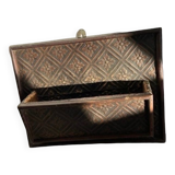 Hammered leather wall mail holder on wood.