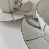 Two Art Deco porcelain cups and saucers with silver trim.