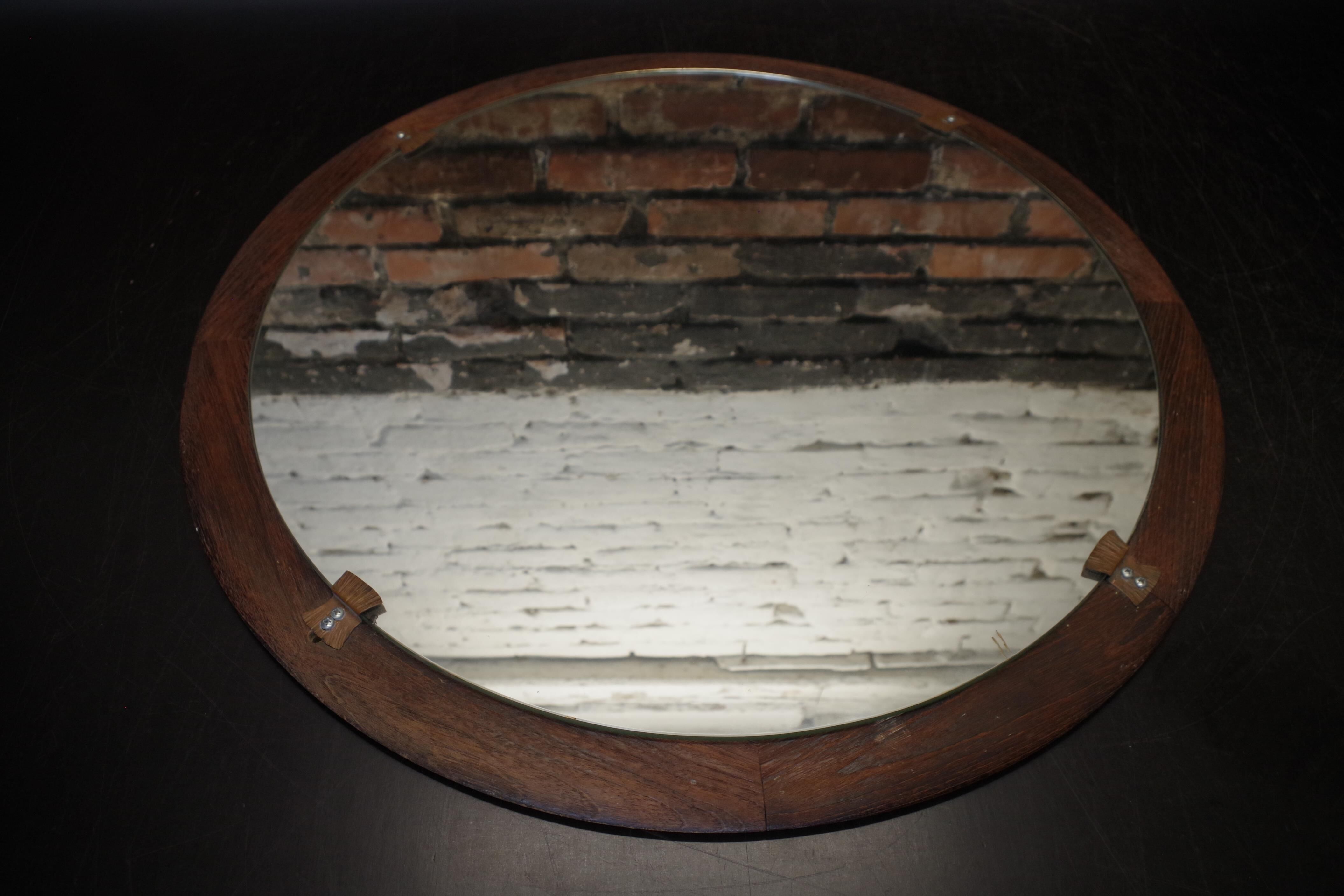 Round mirror in a vintage teak wood frame