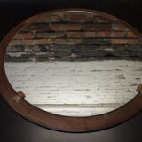 Round mirror in a vintage teak wood frame