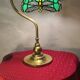 brass lamp with green stained glass shade.