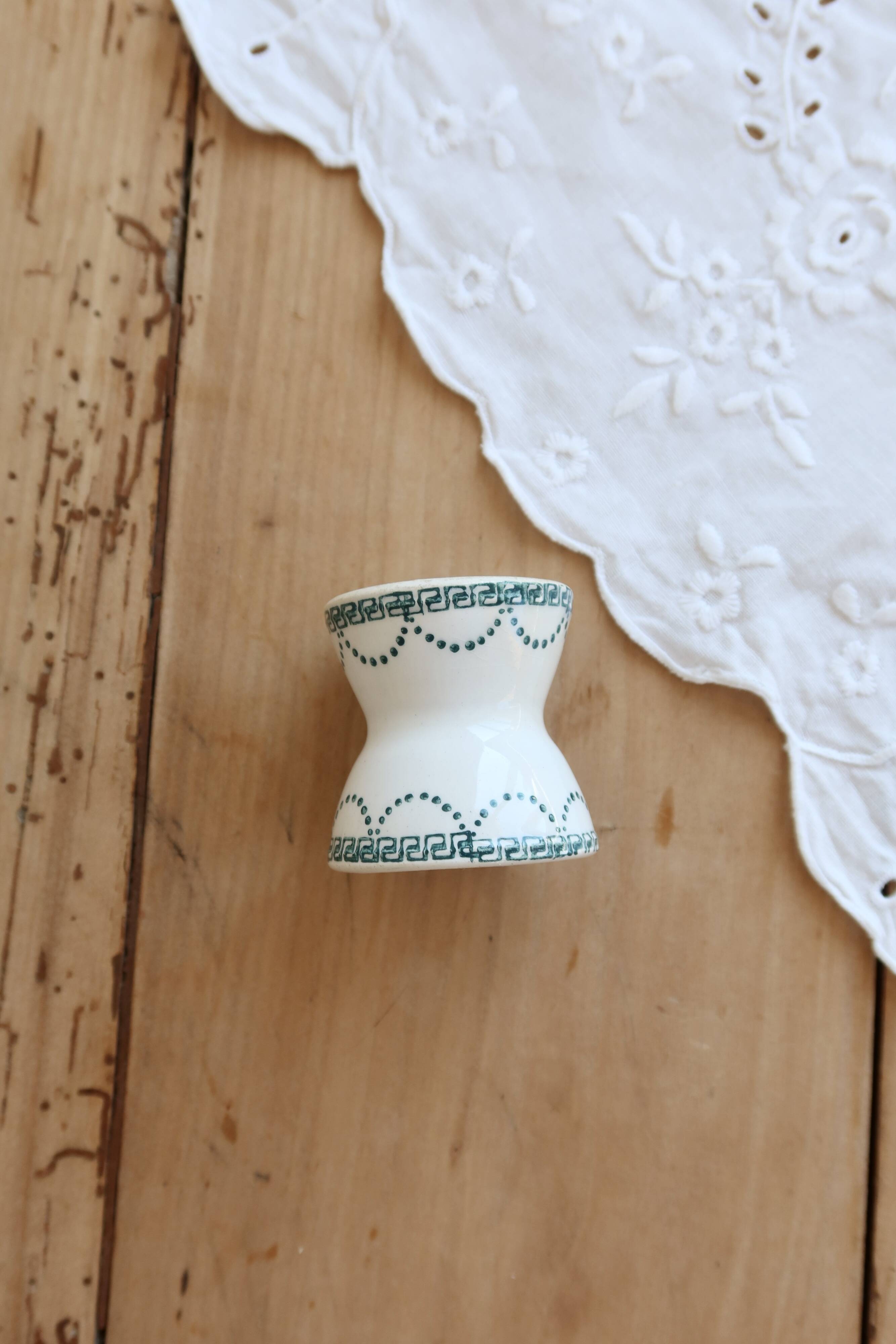 Old diabolo egg cup, ironstone with ivory and green pattern.
