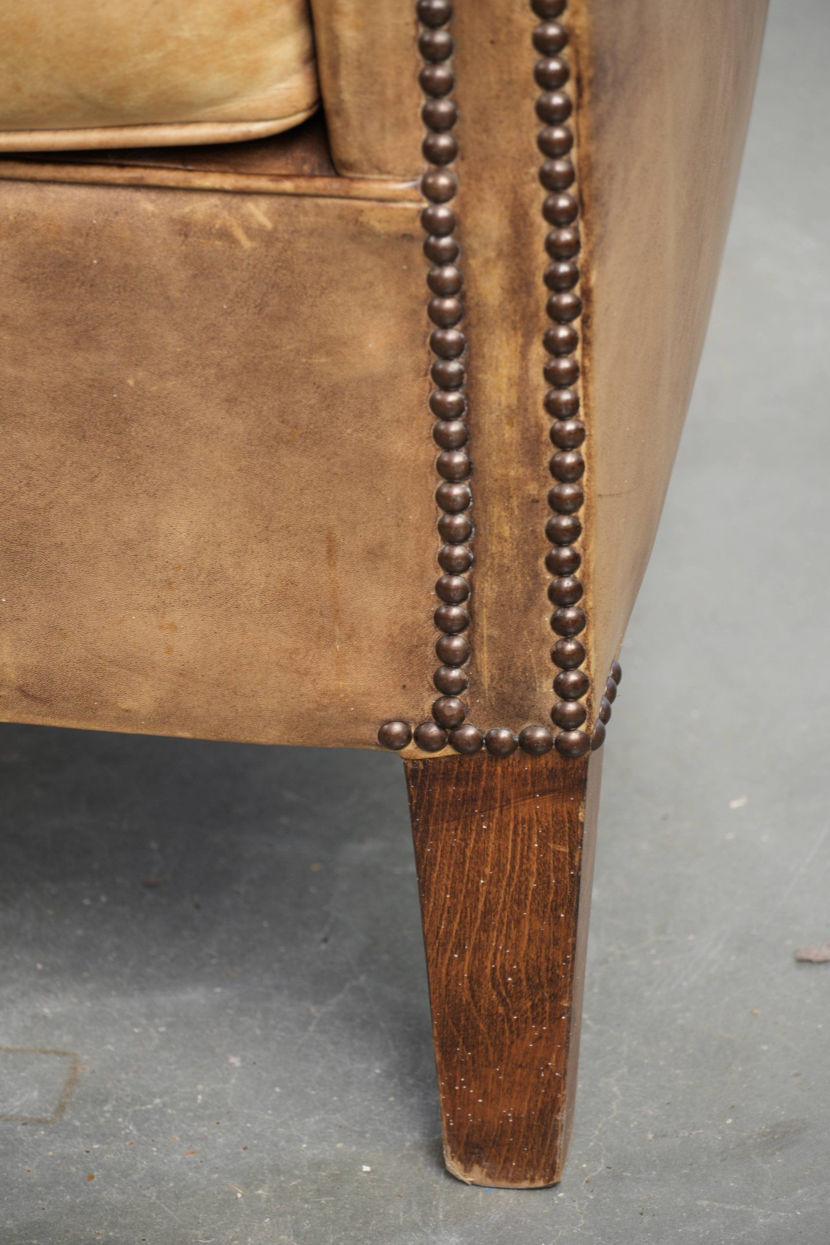Vintage cowhide club armchair in English style in a light colour scheme
