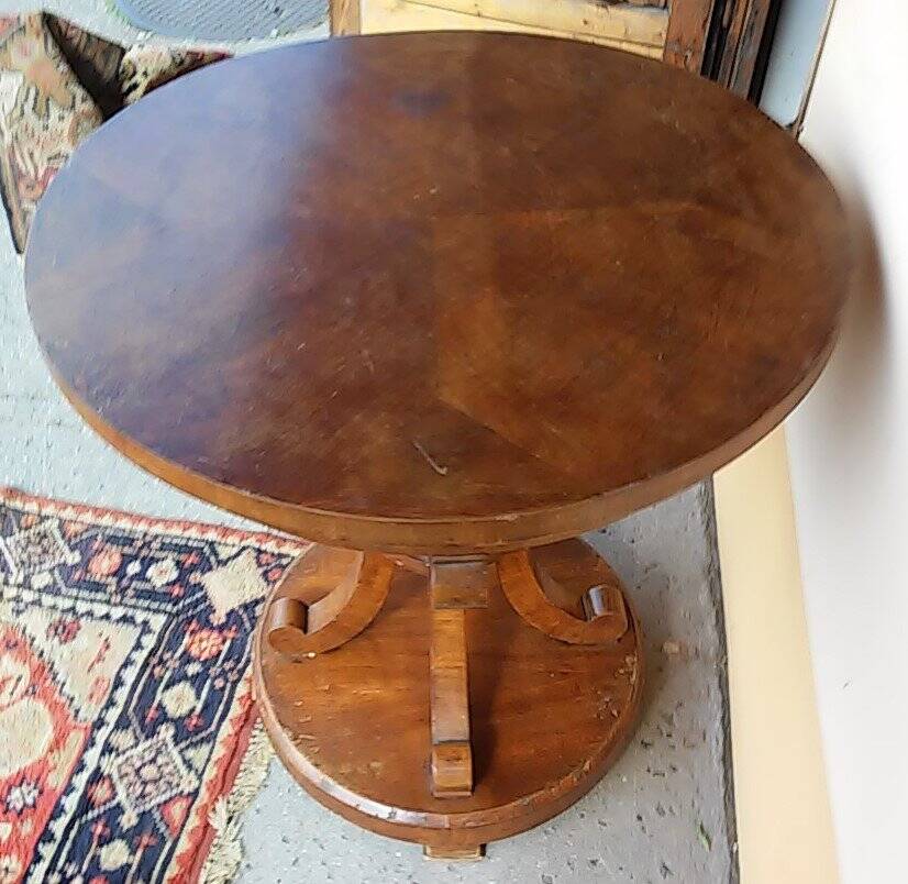 Art Deco side table in brown walnut, round top and scroll legs, France 1930s.