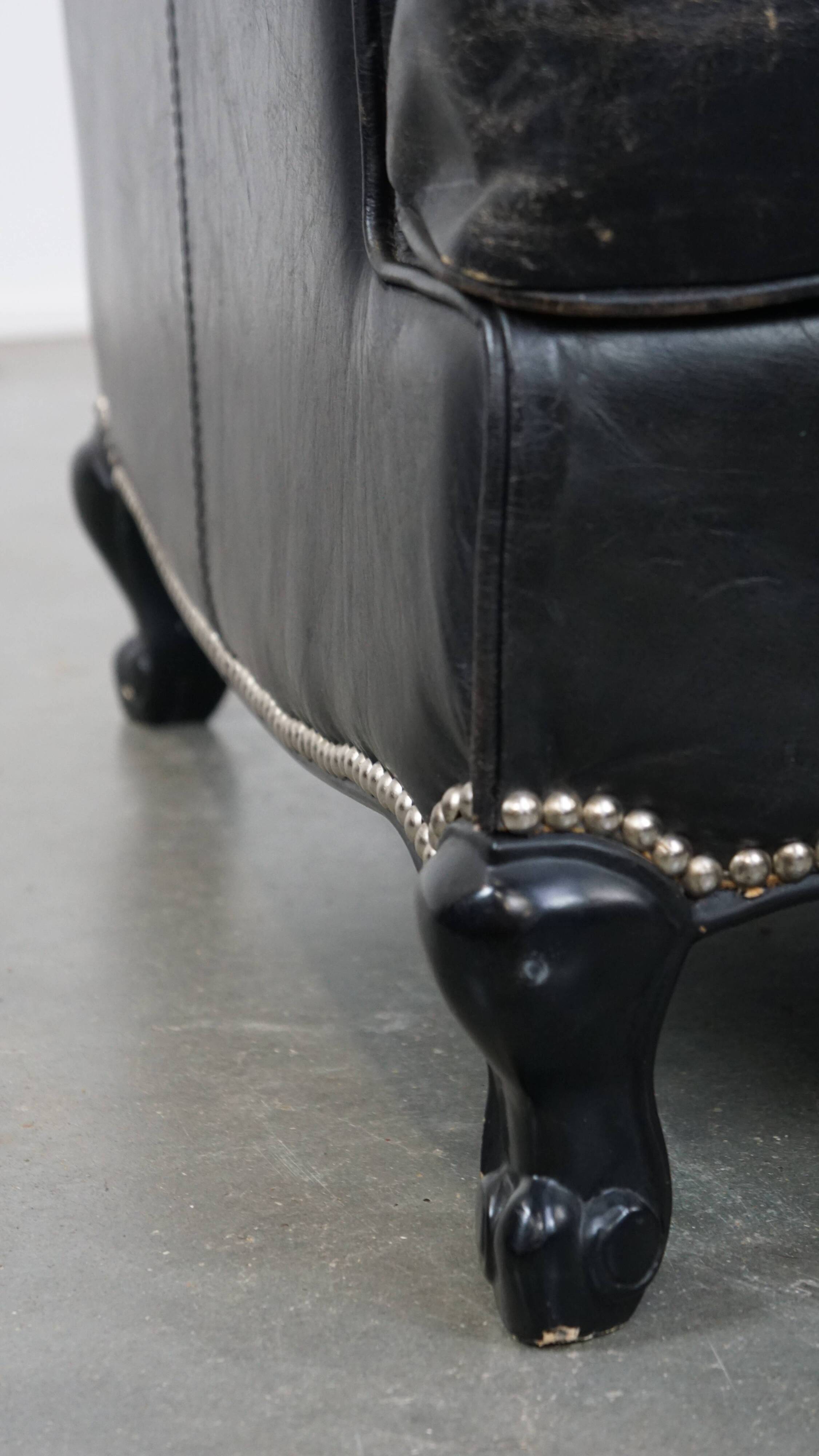 Armchair in black grained cowhide leather with a deep seat