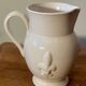 Old white ceramic pitcher with fleur de lys in relief h 14 cm