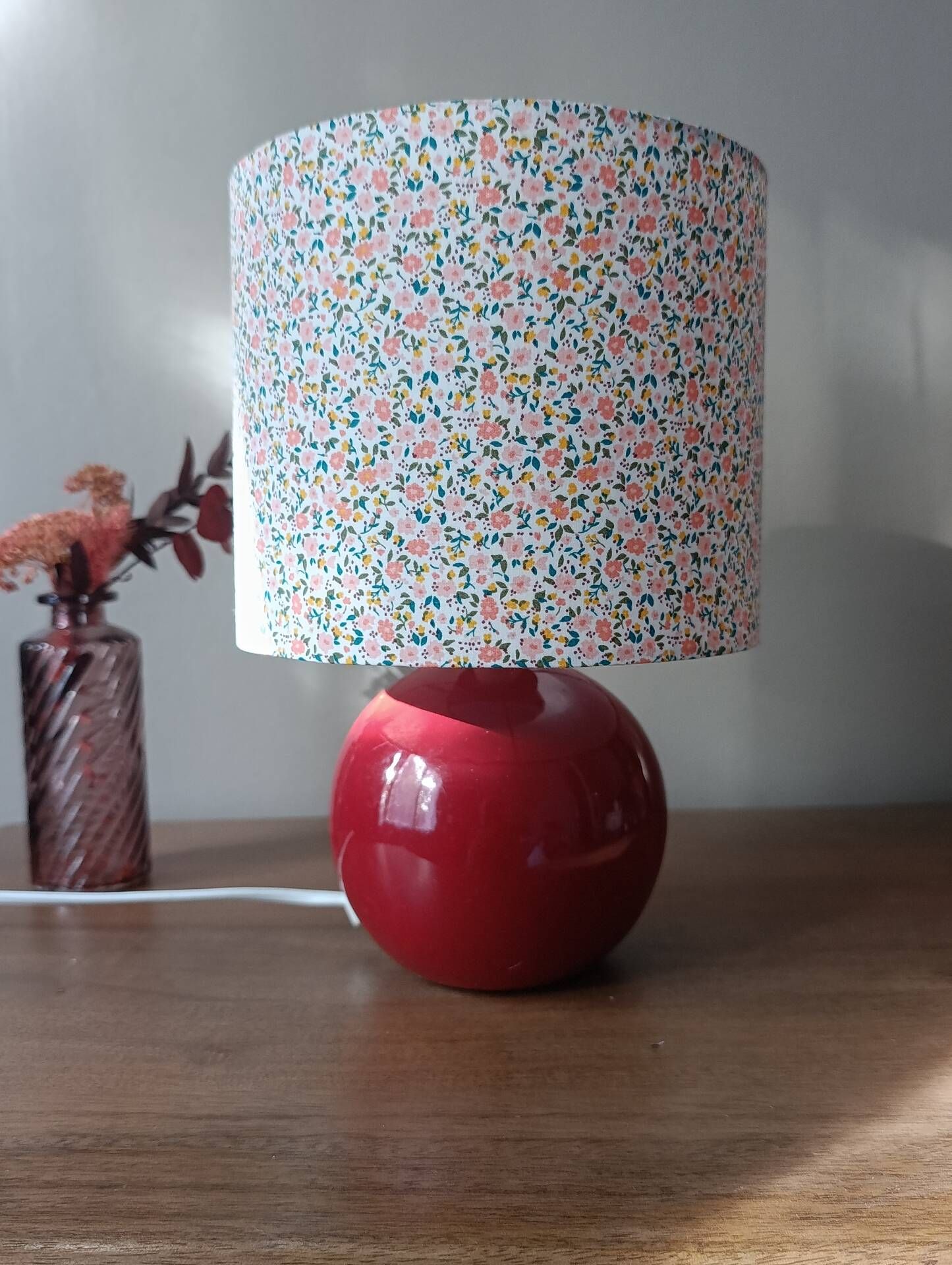 Red bedside lamp, liberty lampshade with small pink flowers.