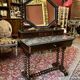 Antique English mahogany dressing table with carved details, black marble, and mirror.