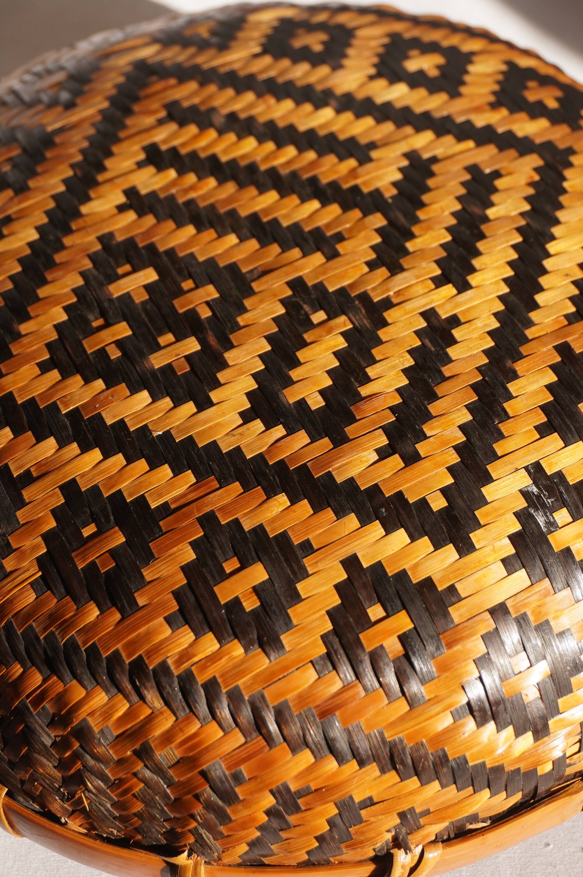 Woven patterned basket, made of straw and bamboo.