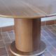 Round table with a central pedestal, light wood, 1990s.