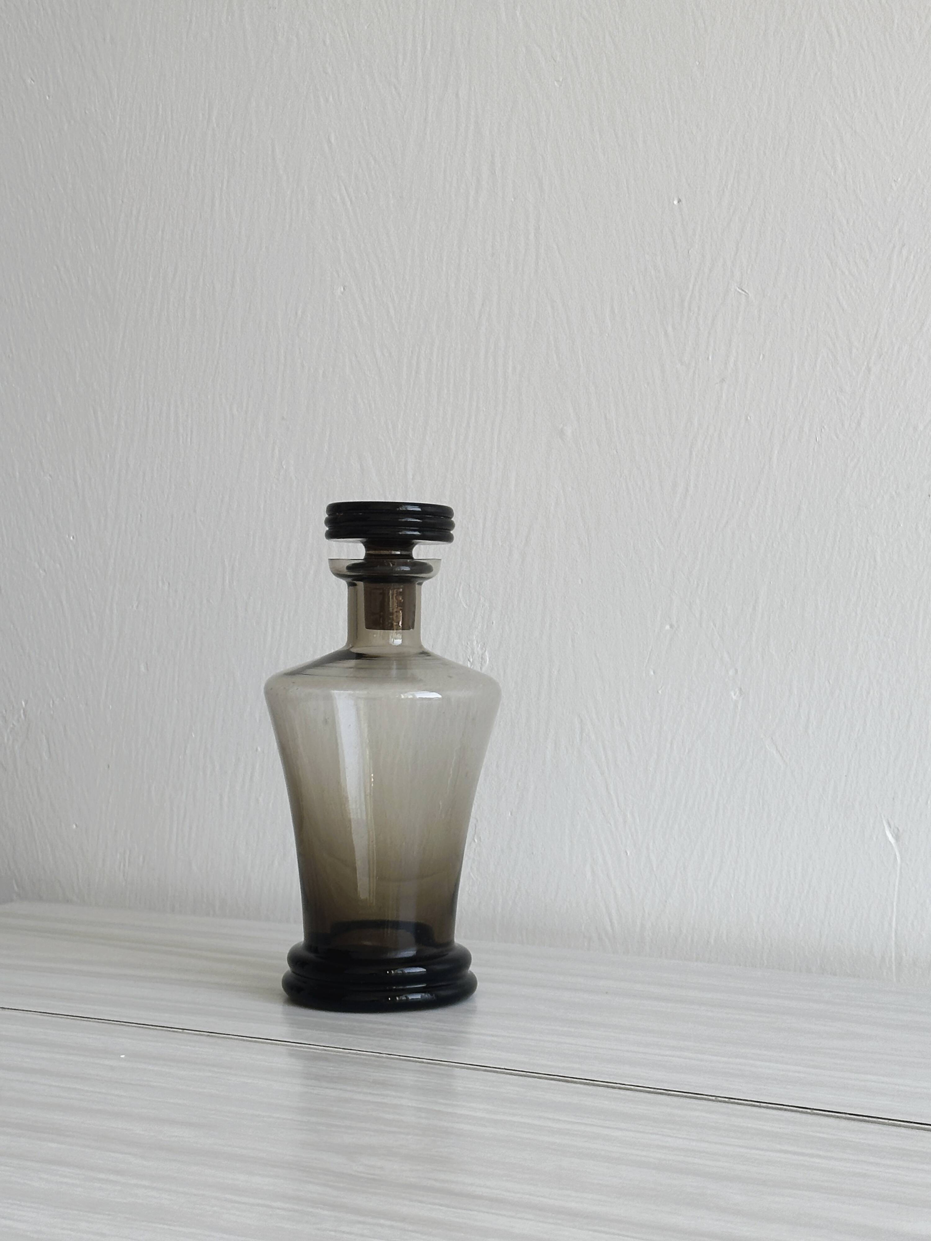Carafe, old smoked glass bottle with sculpted stopper.